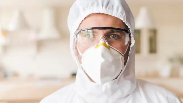 Mold specialist in a protective hood, goggles and respirator